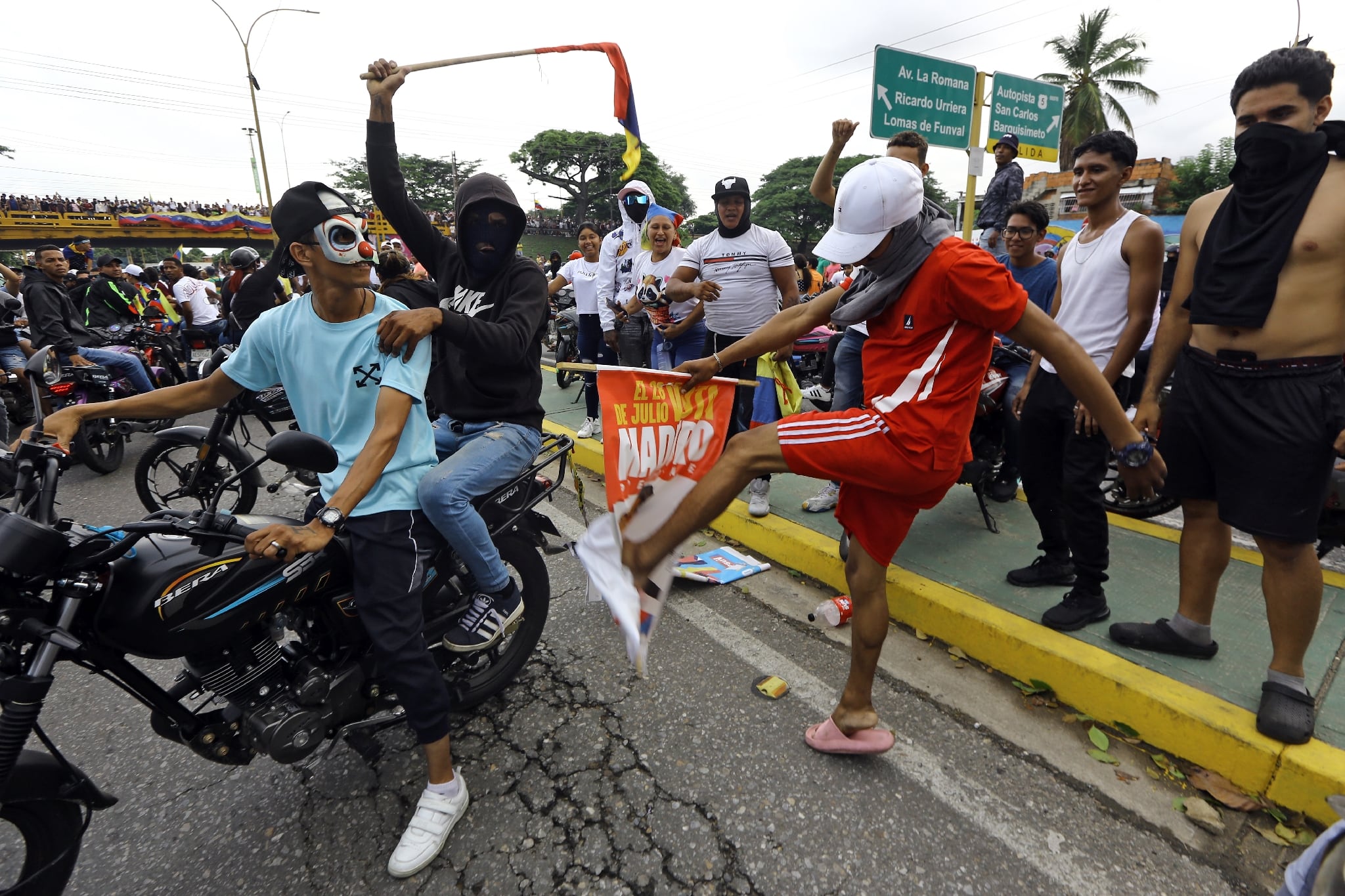 Un manifestant donne un coup de pied dans une bannière de campagne du président vénézuélien Nicolas Maduro lors d'une manifestation à Valencia (Etat de Carabobo), au Venezuela, le 29 juillet 2024