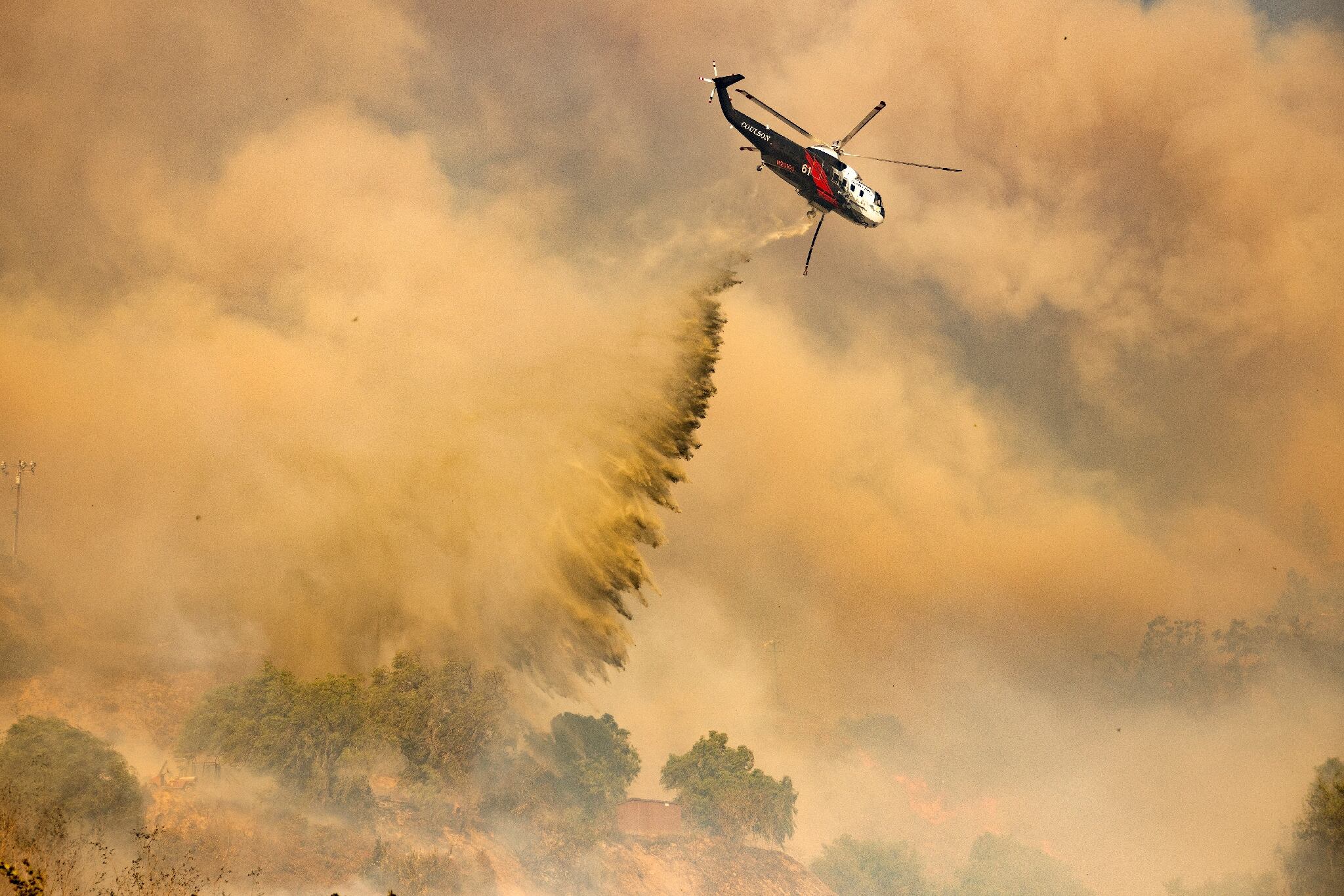 Un hélicoptère de lutte contre les incendies effectue un largage d'eau au-dessus du Mountain Fire à Camarillo, en Californie, le 6 novembre 2024